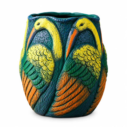 A decorative ceramic planter shaped like two stylized birds facing each other, featuring textured yellow, green, and orange details on a dark teal background, shown against a plain white background.