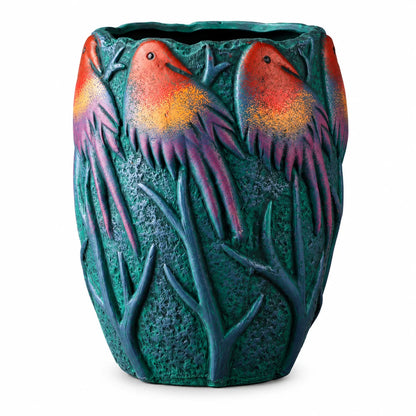 A decorative ceramic planter shaped like a textured green tree trunk with three stylized birds perched on top, featuring a vibrant orange and red gradient on their heads and purple feathers, set against a plain white background.