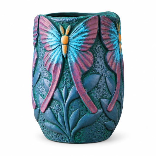 A textured ceramic planter pot featuring embossed butterflies in vibrant turquoise blue and magenta pink, with a dark teal-green base and leafy patterns, shown on a white background.
