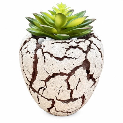 An artificial green succulent plant in a sculpted, heart-shaped ceramic pot with a textured, crackled off-white surface and dark brown fissures, set against a plain white background.